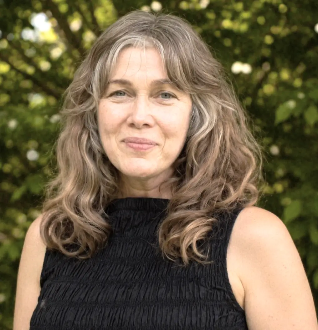 Portrait of Flora Grubb in a black top, in front of green leaves