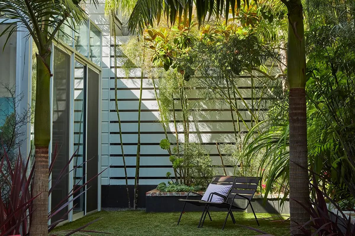 Flora Grubb Gardens: área para sentarse con loveseat en un jardín de San Francisco