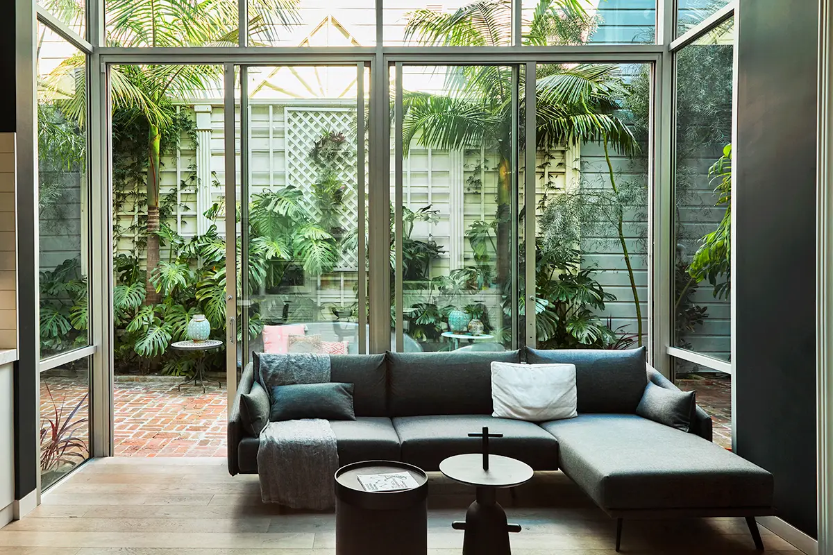 Flora Grubb Gardens: solárium y patio acogedor con monstera y king palms