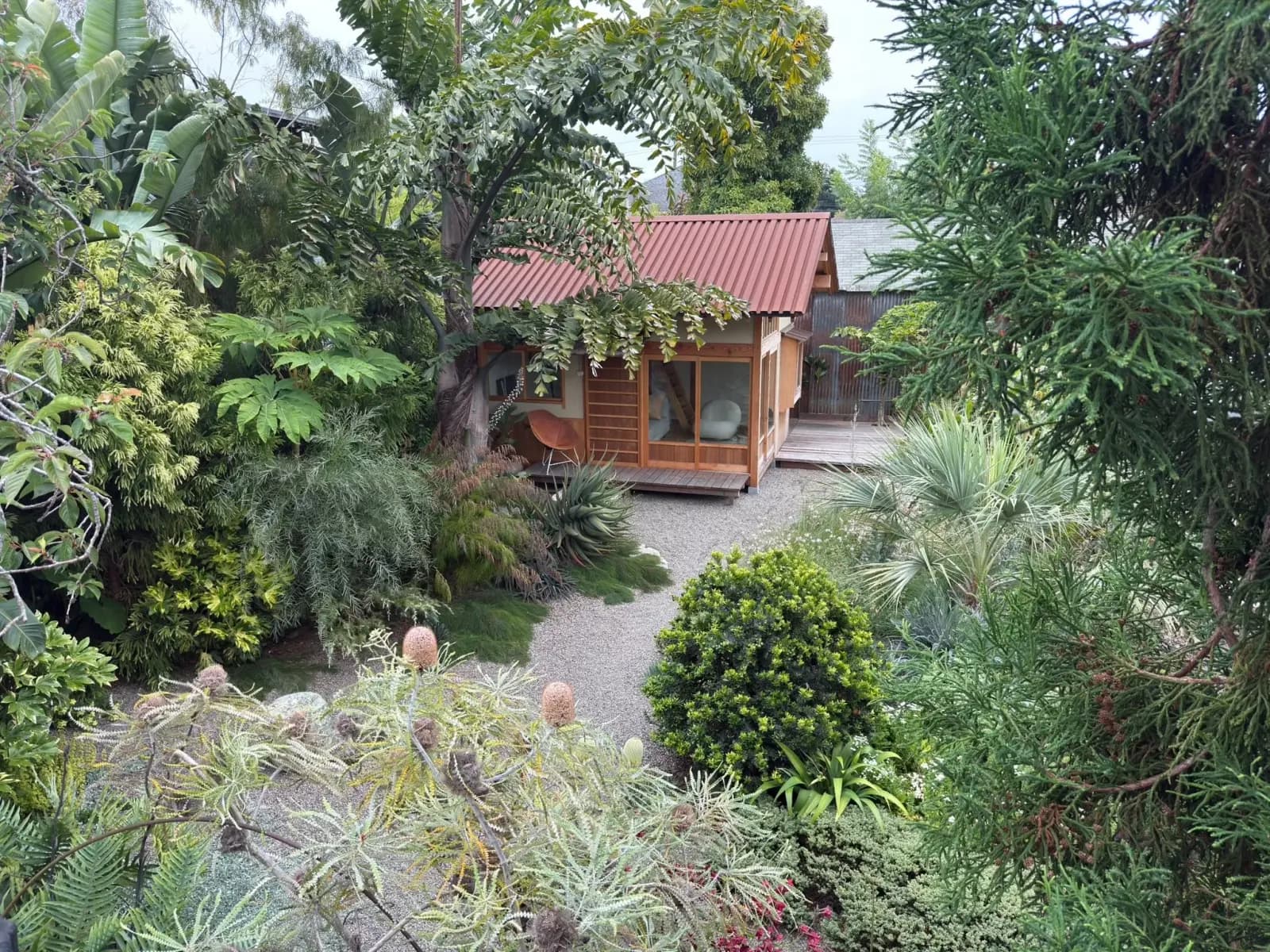El jardín de la casa de Flora Grubb, con una casa de té y plantas exóticas